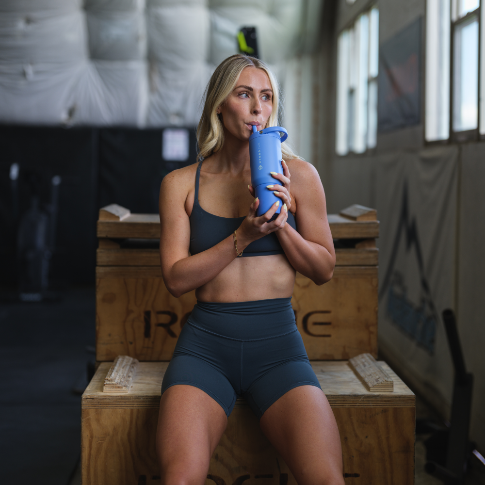 Woman Holding HydroJug Light Blue Sport Bottle 20oz in Gym
