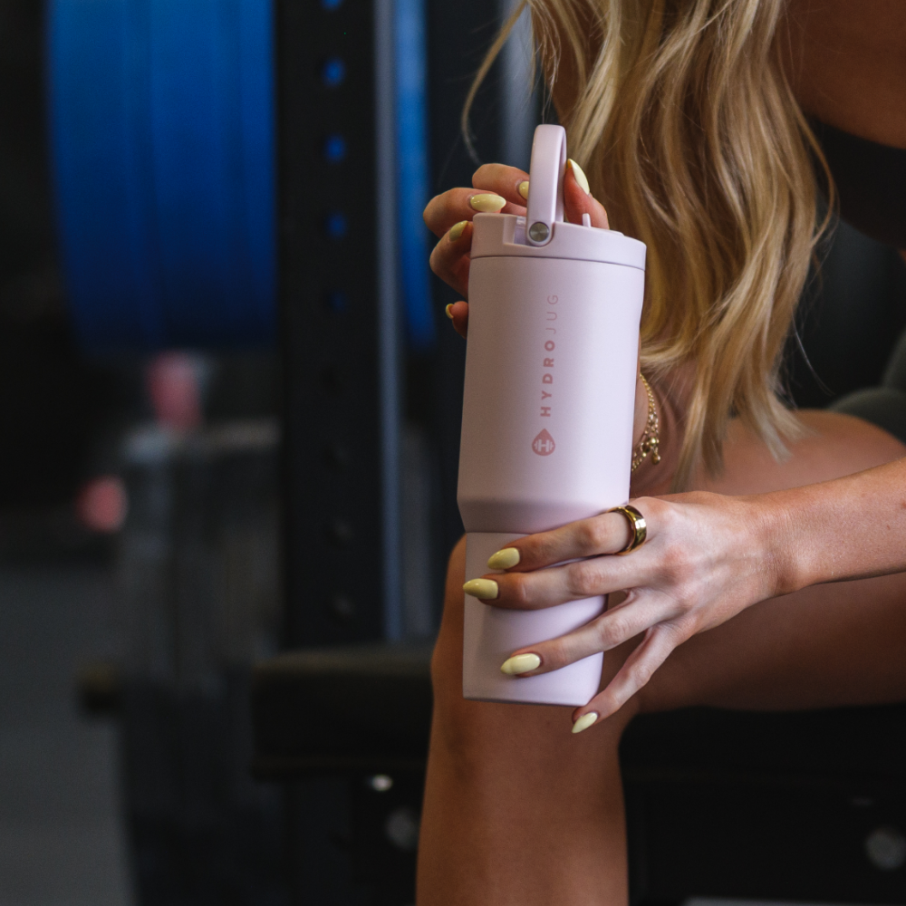 Person Holding HydroJug Pink Sand Sport Bottle 20oz at Gym